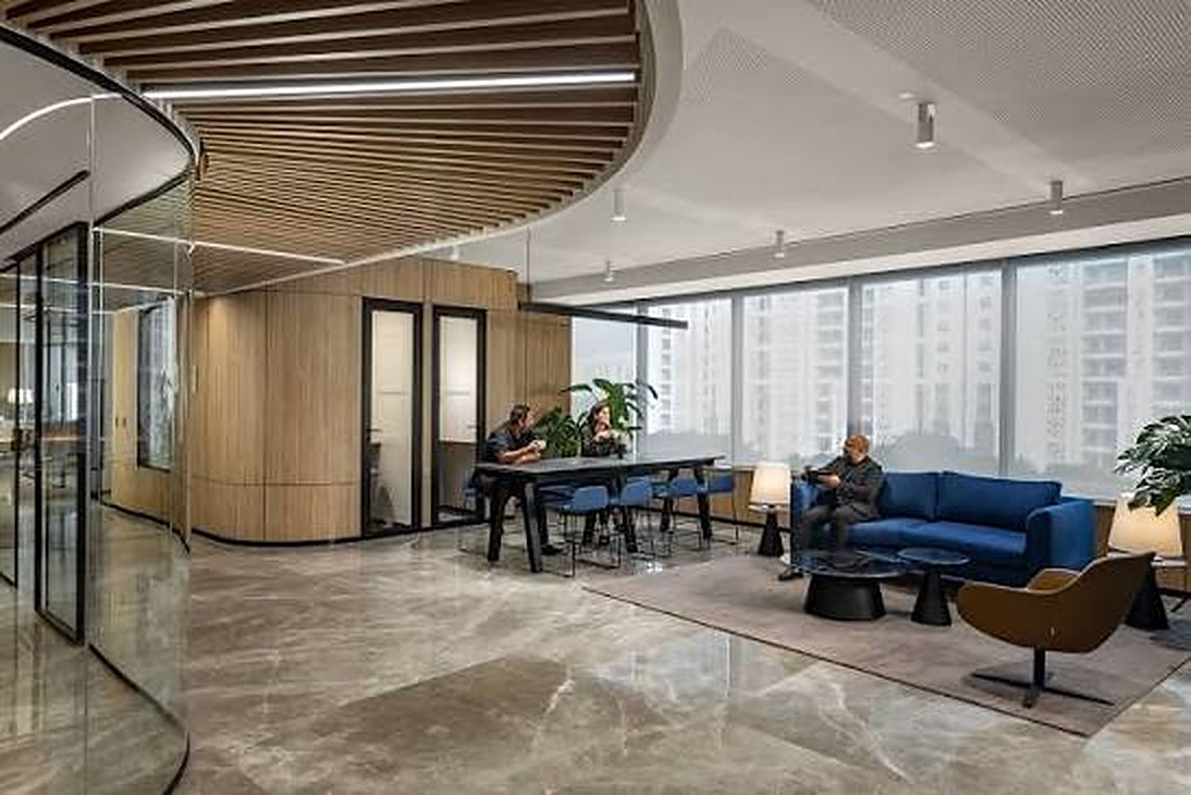 Two people discussing a project at a work table in a bright office lounge