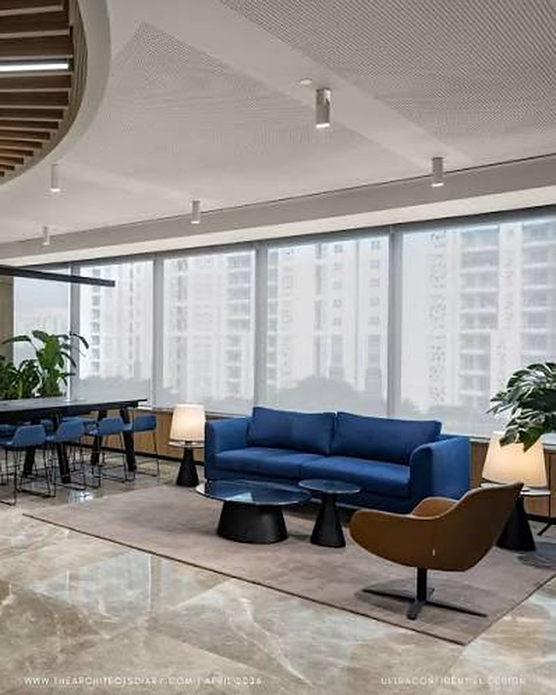 Office lounge with a blue sofa and city views