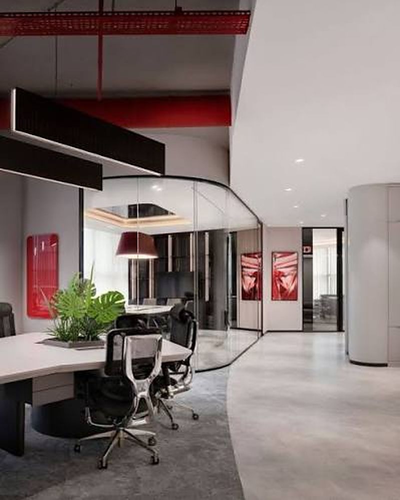 Modern office workspace with desks and a glass meeting room